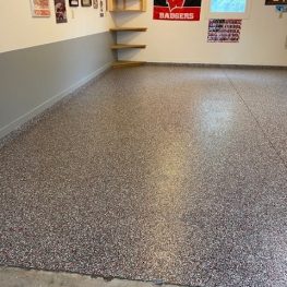 The image shows a tidy garage interior with speckled flooring. Sports memorabilia decorate the walls, suggesting the owner is a sports enthusiast.